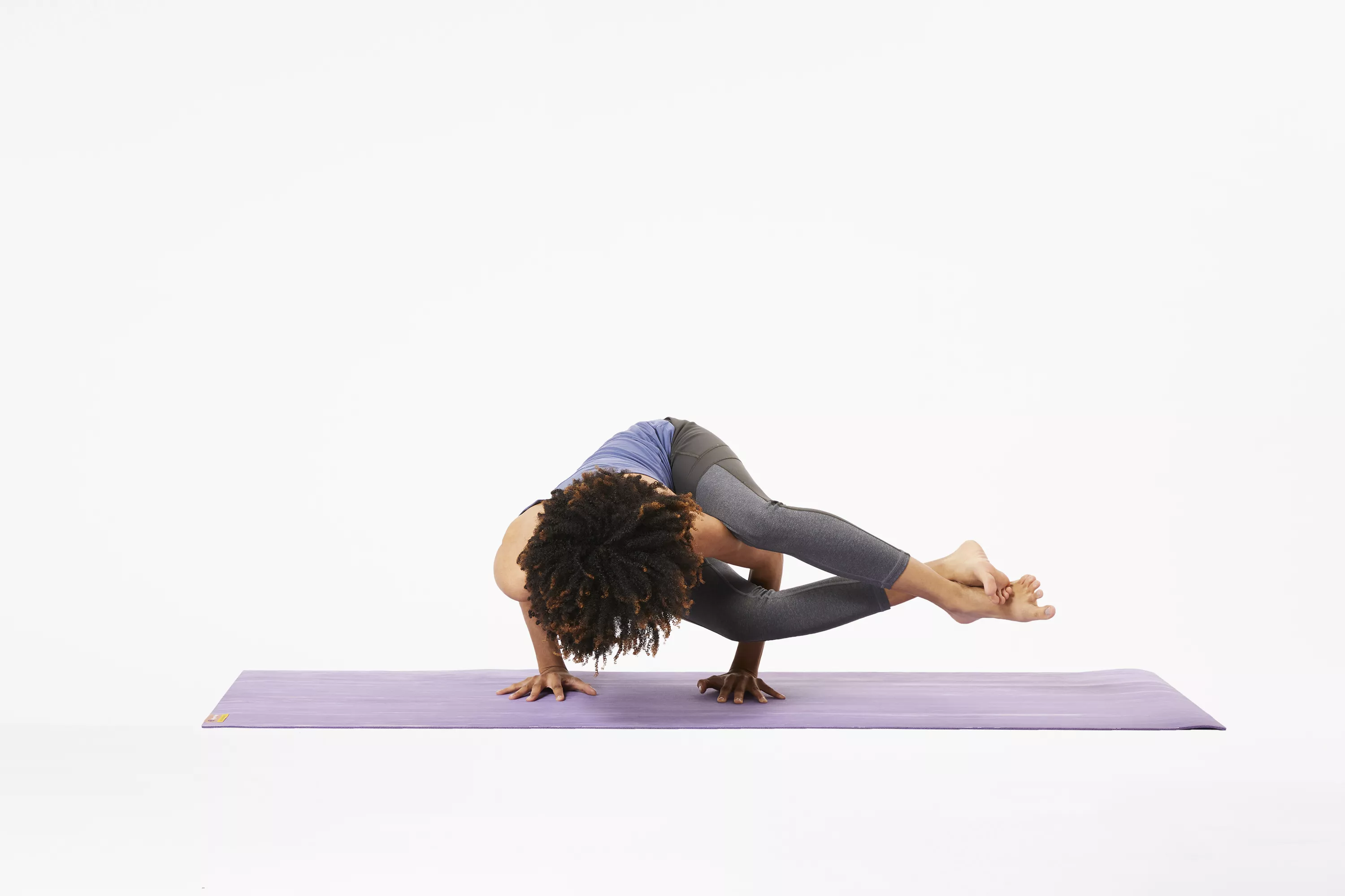 Woman on yoga mat in eight angle pose