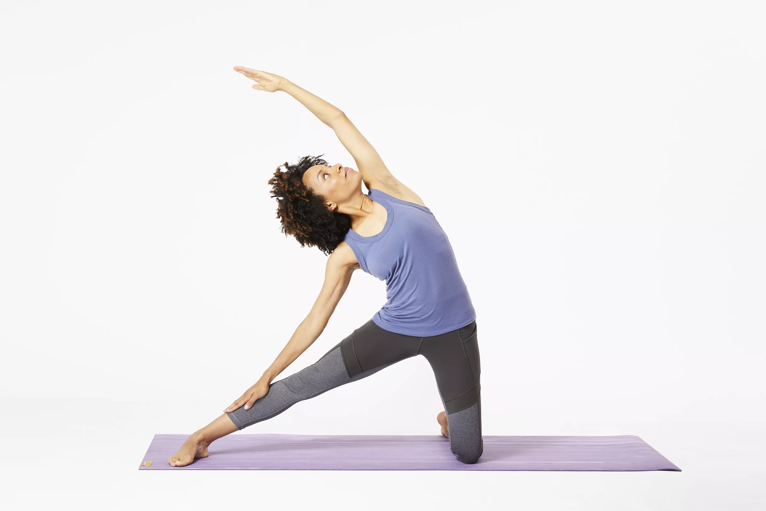 Woman doing gate pose on yoga mat