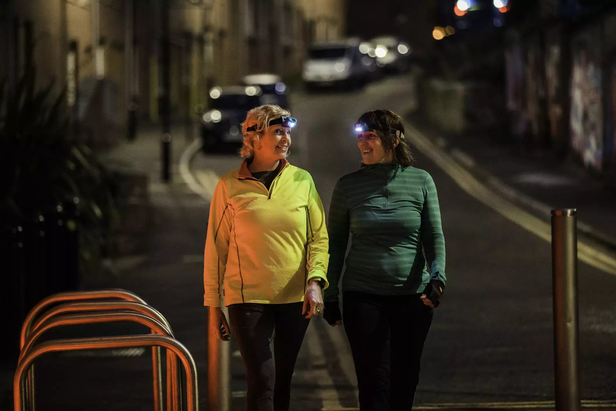 Two friends with headlamps walking together at night