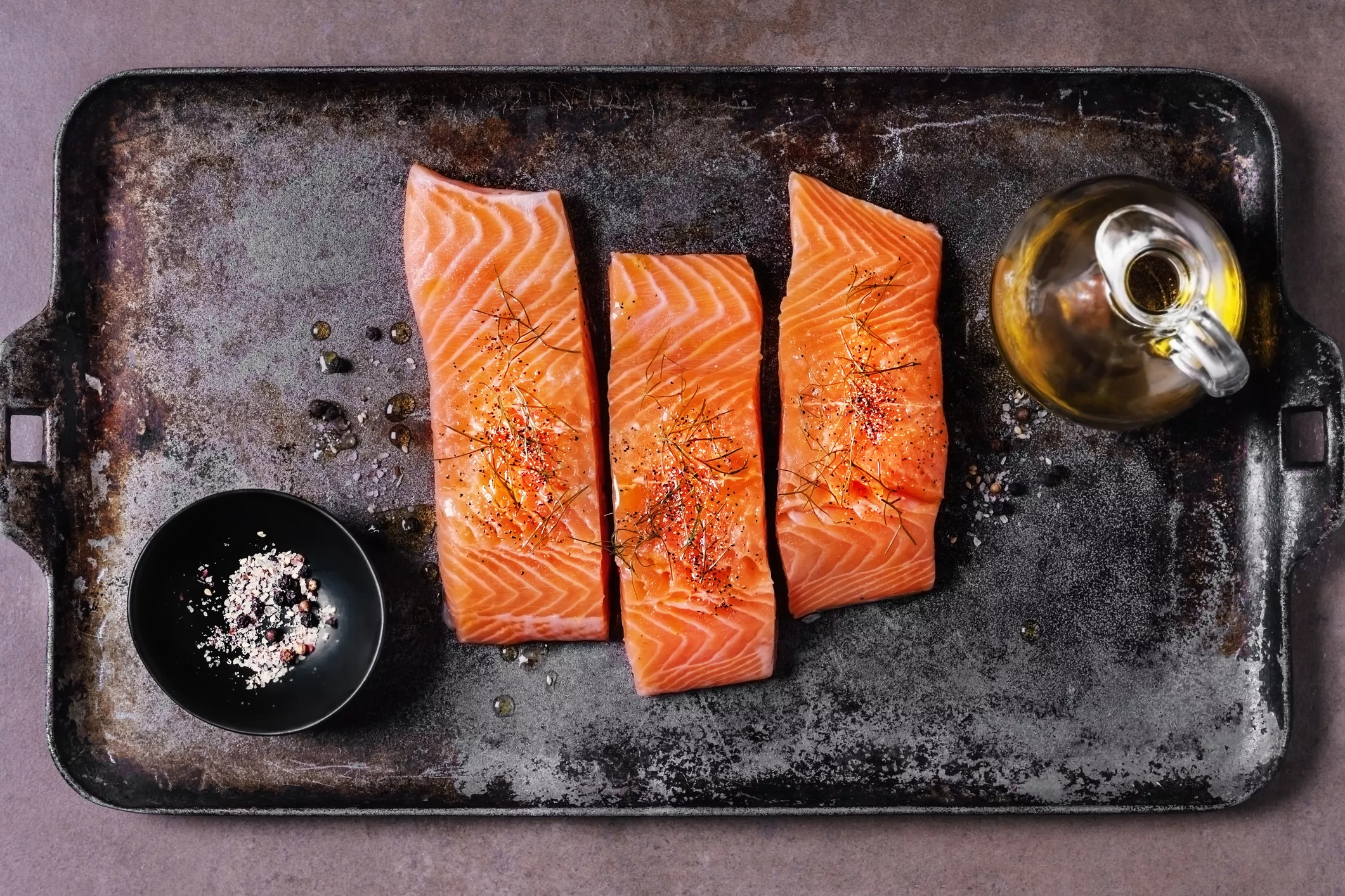 salmon on a baking sheet with olive oil and salt and pepper