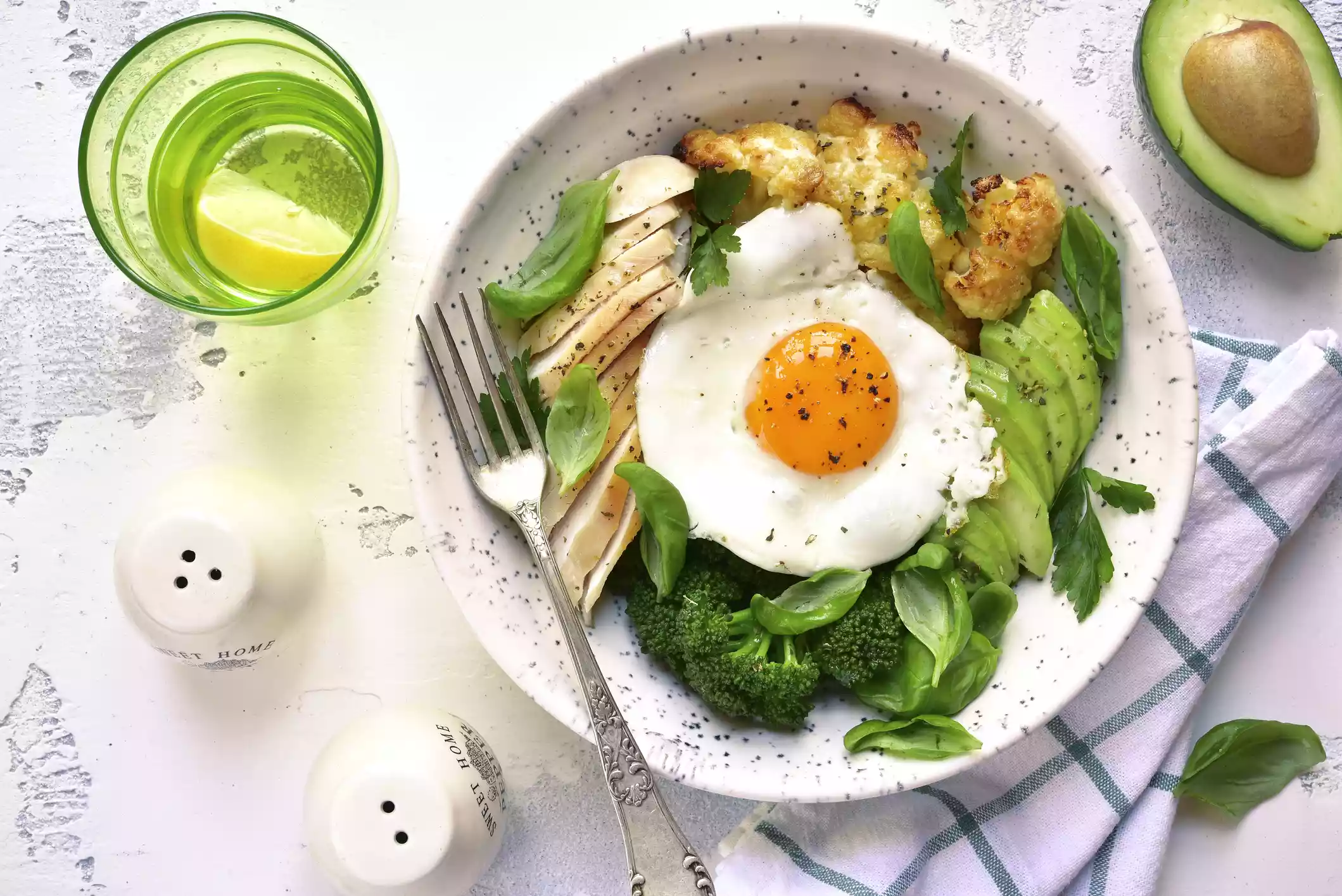 eggs, broccoli, avocado, chicken, and cauliflower in white bowl